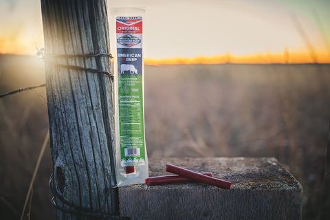 Original beef stick on a ranch fence post at sunset